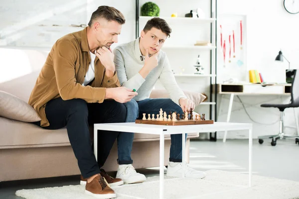 Pensive Father Teen Son Playing Chess Home — Stock Photo, Image