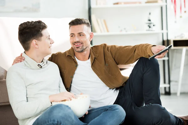 Smiling Father Teen Son Hugging Watching Holding Bowl Popcorn Home — Free Stock Photo