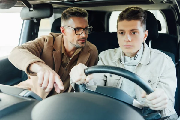 Handsome Father Teaching Teen Son Driving Car Pointing Something — Stock Photo, Image