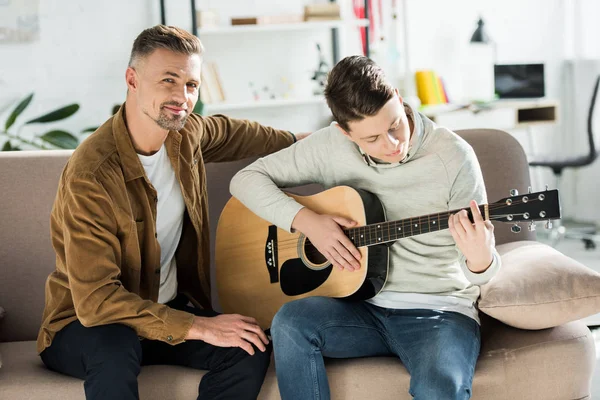 Teen Γιος Παίζοντας Ακουστική Κιθάρα Για Πατέρα Στο Σπίτι — Φωτογραφία Αρχείου