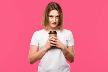 Tek kullanımlık bardak kahve pink izole tutan güzel genç kadın