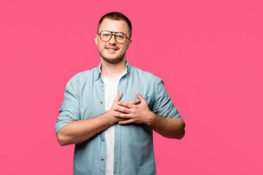 kalp yukarıda elele ve pink izole kamera gülümseyen gözlük mutlu genç adam