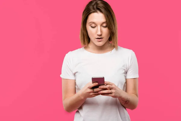 美丽的女孩使用智能手机隔离粉红色 — 图库照片