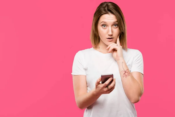 Verrast Meisje Met Smartphone Kijken Camera Geïsoleerd Roze — Stockfoto