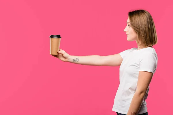 Vue Latérale Fille Montrant Tasse Jetable Café Isolé Sur Rose — Photo