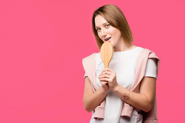 Jonge Vrouw Zingen Haarborstel Kijken Naar Camera Geïsoleerd Roze — Gratis stockfoto