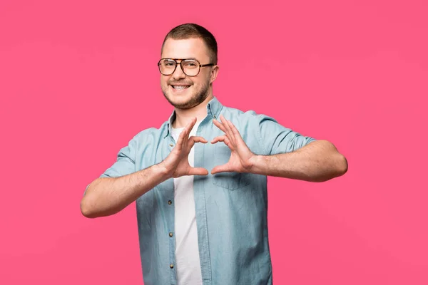 Gelukkig Jonge Man Hand Hartsymbool Tonen Lachend Camera Geïsoleerd Roze — Stockfoto