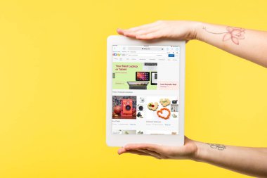 ekranda sarı izole ebay Web sitesi ile dijital tablet tutan kişi kırpılmış atış  