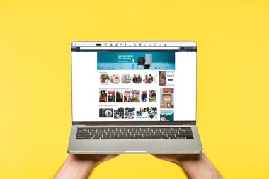 amazon Web ile dizüstü bilgisayar ekranında sarı izole tutan kişi kırpılmış atış