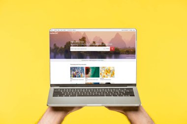 Kırpılan shutterstock Web sitesi ile dizüstü bilgisayar ekranında sarı izole tutan kişi resmini