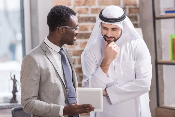 African American Businessman Holding Digital Tablet Looking Arabian Partner — Stock Photo, Image
