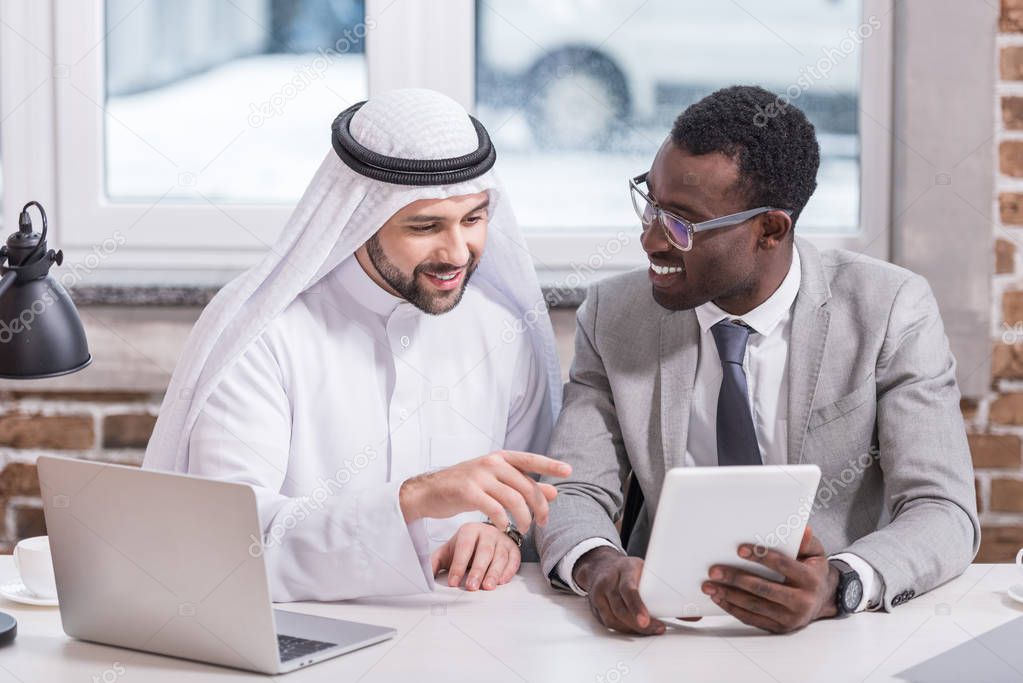Arabian businessman pointing at digital tablet in modern office 