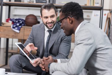 Afrika kökenli Amerikalı işadamı iş ortakları dijital tablet Office bakarak