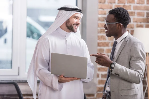 Americký Podnikatel Ukazuje Notebooku Při Pohledu Arabský Partner — Stock fotografie