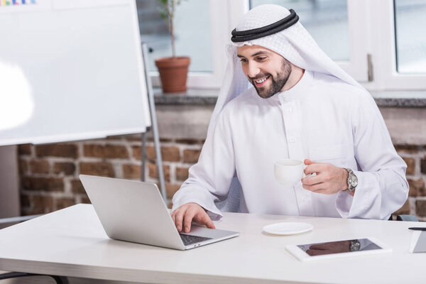 Arabian businessman typing on laptop keyboard in office 