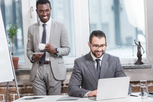 Parceiros Negócios Multiculturais Sorridentes Olhando Para Laptop Escritório — Fotografia de Stock