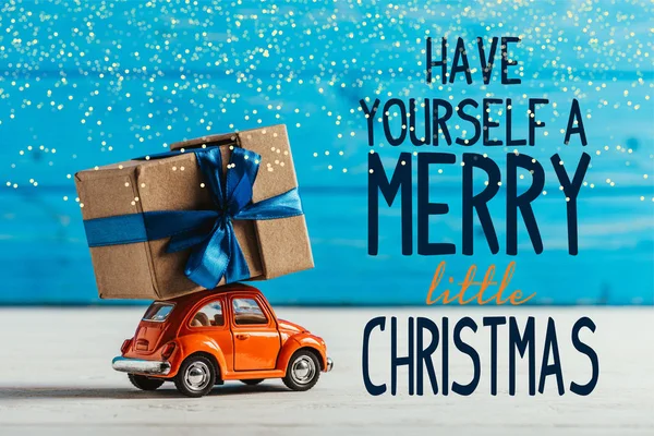 自分があるメリー リトル クリスマス インスピレーションと青い木製の背景にギフト ボックスとおもちゃの車のクローズ アップ ショット — ストック写真
