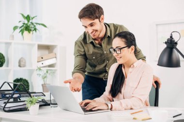 tipik dizüstü bilgisayar klavye arkasında ve ekran Office gösteren iş arkadaşınız ile güzel ofis müdürü