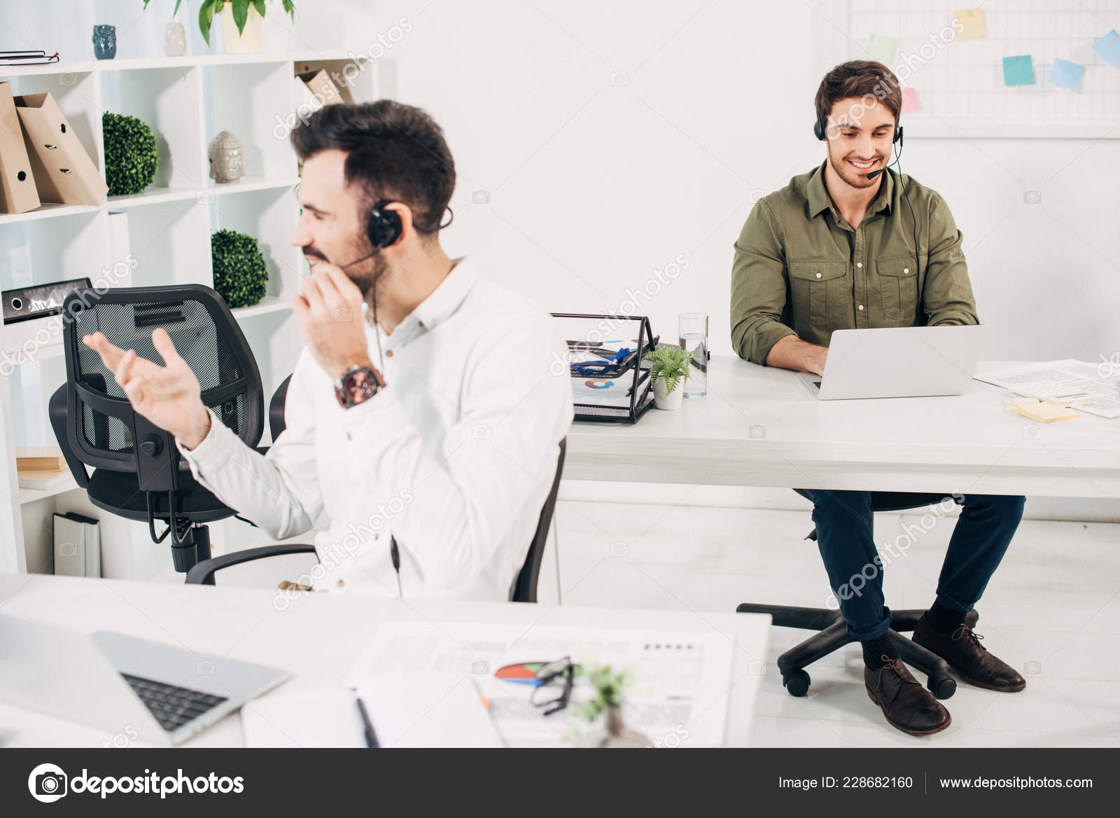 Male Operators Using Headsets While Working Modern Call Centre