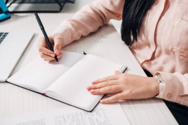 Kalem tutan ve not defterinde yazılı kadın görünümünü kırpılmış