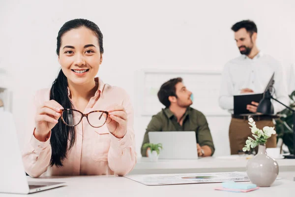 Young Female Manager Holding Glasses Smiling Office — Free Stock Photo