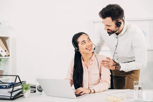 Gerente Feminina Olhando Para Colega Trabalho Masculino Fones Ouvido Sorrindo — Fotografia de Stock