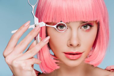 çekici şehvetli kız mavi izole makas bakarak pembe saç modeli ile