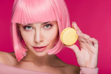 pembe peruk pink izole sarı macaron ile poz çekici genç kadın