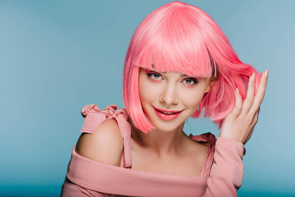 fashionable sensual girl posing in pink wig isolated on blue