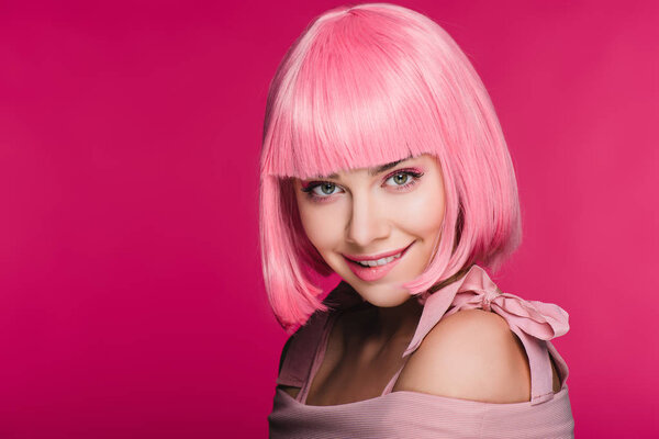 beautiful stylish young woman in pink wig biting lip, isolated on pink