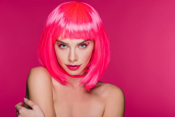 attractive stylish naked girl posing in neon pink wig, isolated on pink