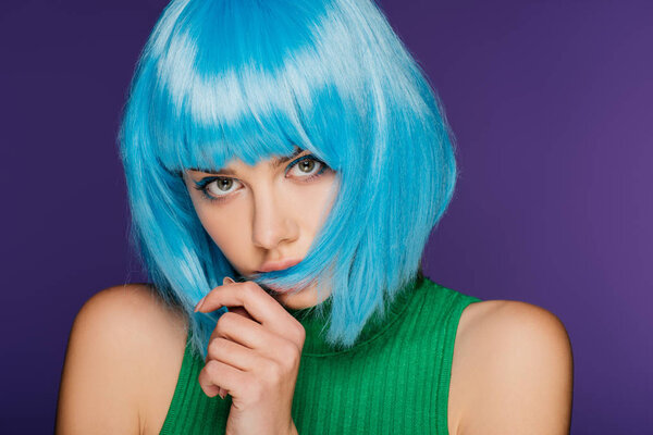 beautiful girl posing in trendy blue wig, isolated on purple