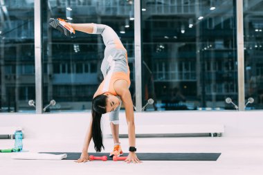 spor salonunda fitness mat streç egzersiz yaparak ince Asya sporcumuz