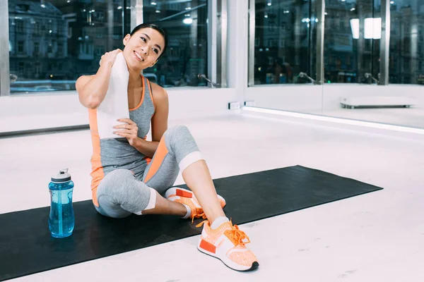 Sonriente Asiático Chica Sentado Fitness Mat Con Toalla Moderno Gimnasio — Foto de Stock