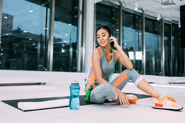 Hermosa Asiático Sportswoman Sentado Fitness Mat Hablando Smartphone Gimnasio — Foto de Stock