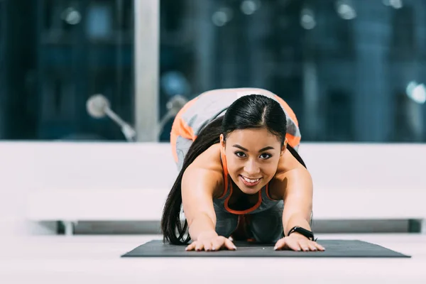 Aantrekkelijke Aziatische Sportvrouw Doen Stretch Oefeningen Fitness Mat Lachend Sportschool — Gratis stockfoto