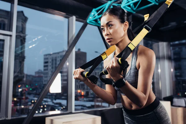 Athletische Asiatische Sportlerin Trainiert Mit Widerstandsbändern Fitnesszentrum — kostenloses Stockfoto