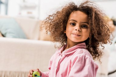 gülümseyen kıvırcık Afro-Amerikan çocuk kameraya bakıyor
