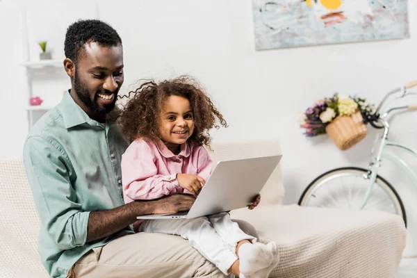 Afrikalı Amerikalı Babası Kanepede Oturan Dizüstü Bilgisayar Kullanarak Sevimli Çocuk — Stok fotoğraf