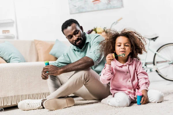 Afrikanisch Amerikanischer Vater Und Tochter Machen Seifenblasen Und Sitzen Auf — Stockfoto