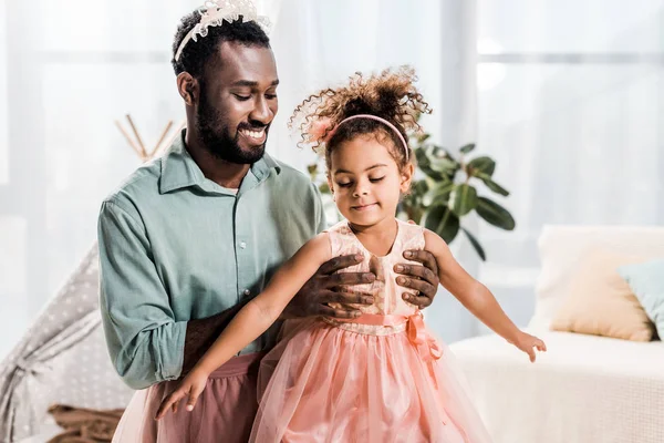 Glücklich Lächelnder Afrikanisch Amerikanischer Vater Hebt Tochter Rosa Kleid Hoch — Stockfoto