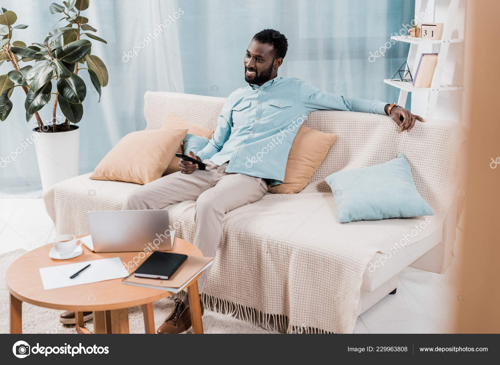 African American Man Watching Sitting Sofa Living Room Stock Photo African American Man Watching Sitting Sofa Living Room Stock Photo
