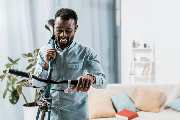 African American Man Carrying Bike Shoulder Living Room — Free Stock Photo