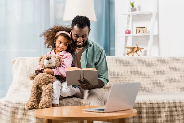 Afrikanisch Amerikanischer Mann Liest Mit Tochter Wohnzimmer — kostenloses Stockfoto
