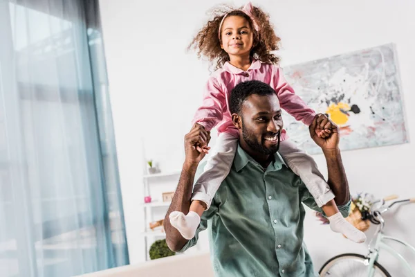 Africano Americano Padre Llevar Hija Cuello Sala Estar — Foto de stock gratis