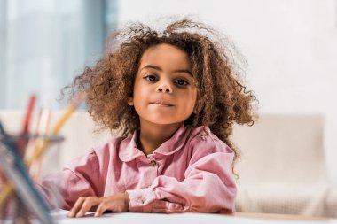 Afro-Amerikan çocuk oturma odasında renkli kalemler ile çizim
