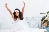 boldog fiatal afrikai-amerikai nő, bekötött szemmel a homlok nyújtás az ágyban reggel időben otthon