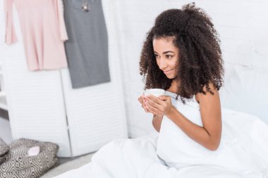 Afro-Amerikan kız yatakta kahve evde sabah zaman sırasında holding