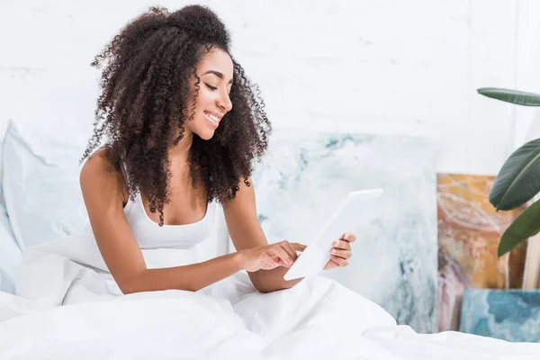 Felice Donna Afroamericana Giovane Utilizzando Tablet Digitale Letto Durante Mattino — Foto stock gratuita