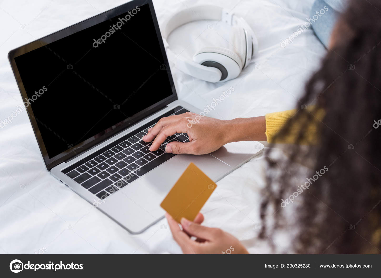 クレジット カードを持っていると 自宅のベッドでノート パソコンでオンライン ショッピングを行う女性の部分的なビュー 無料のストック写真 C Edzbarzhyvetsky